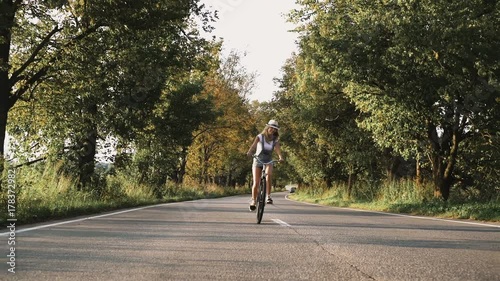 Wallpaper Mural a young blonde girl in pants on retro bike going down the road in the field Torontodigital.ca