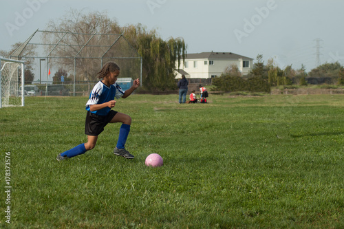 Young girl playing soccer at the park
