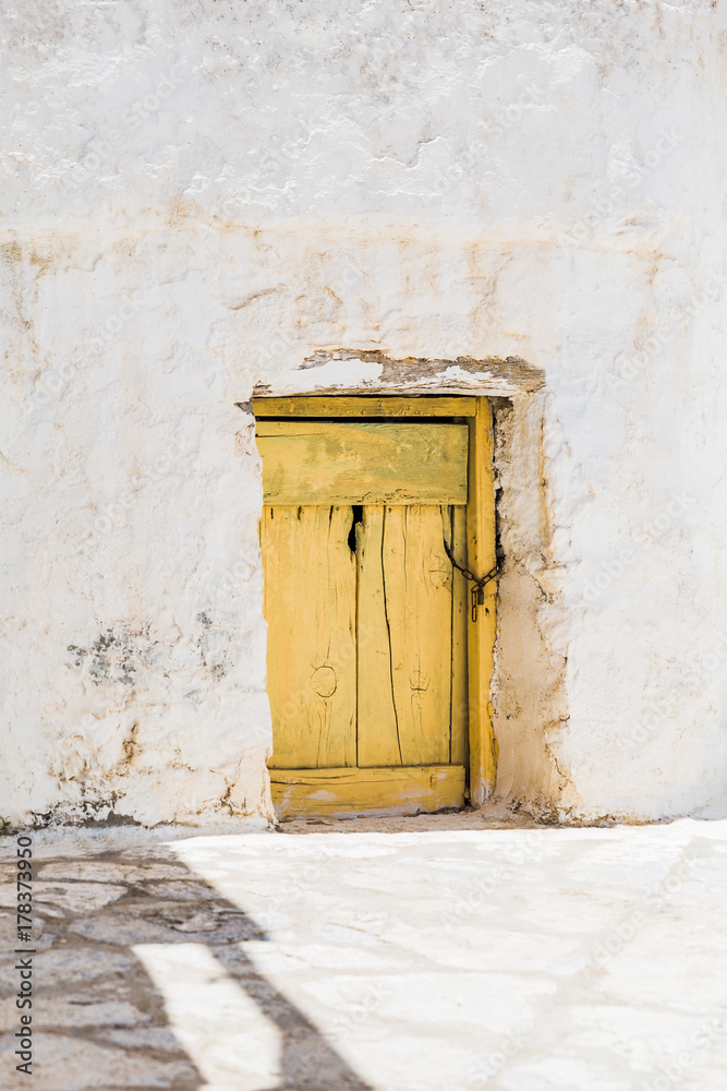 Fototapeta premium Yellow wooden door on Amorgos island, Cyclades of Greece.