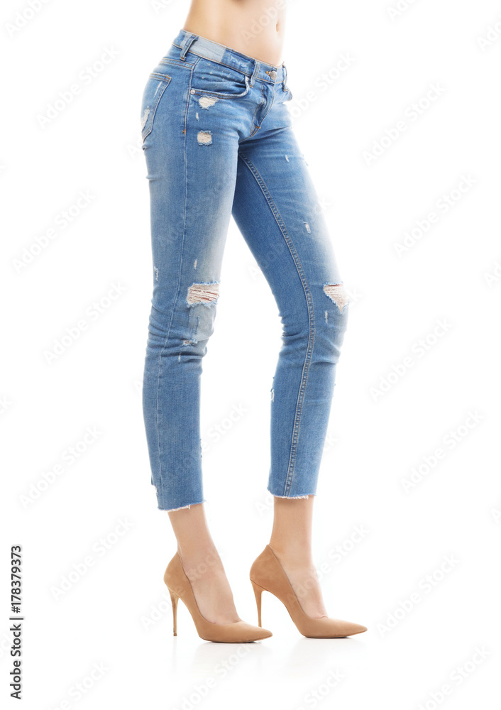 Slim and sexy female legs in jeans isolated on white. Slim and sexy female legs in jeans isolated on white.