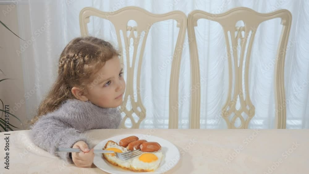 Little girl has breakfast at the kitchen Little girl has breakfast at the kitchen