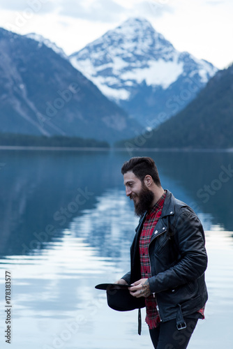 Stylish tattoed Hipster Man enjoys scenic mountain lake in Austria © benicoma