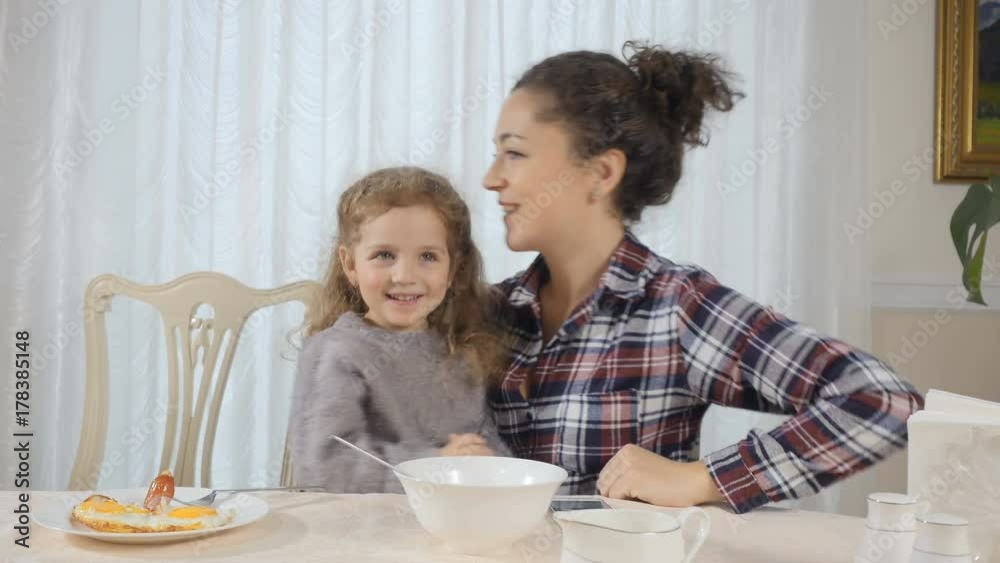 Woman and daughter have fun during breakfast