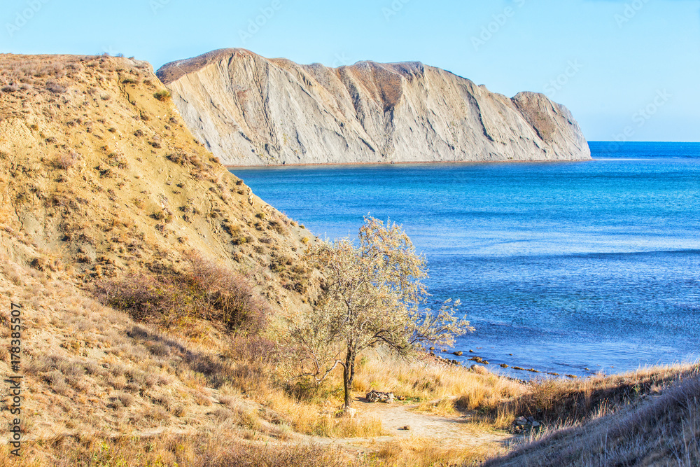 Fototapeta premium Rocky beach sunny sky and mountains