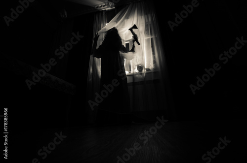 Horror woman in window wood hand hold cage scary scene halloween concept Blurred silhouette of witch. Selective focus