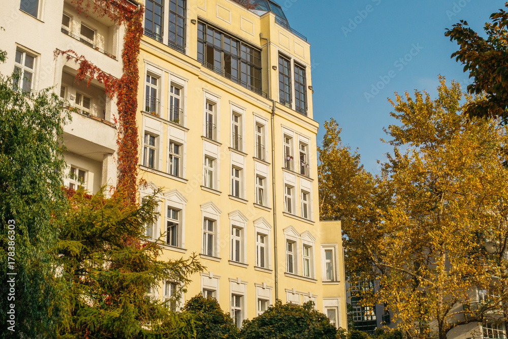 Fototapeta premium modern apartments framed by ivy and trees in autumn colors