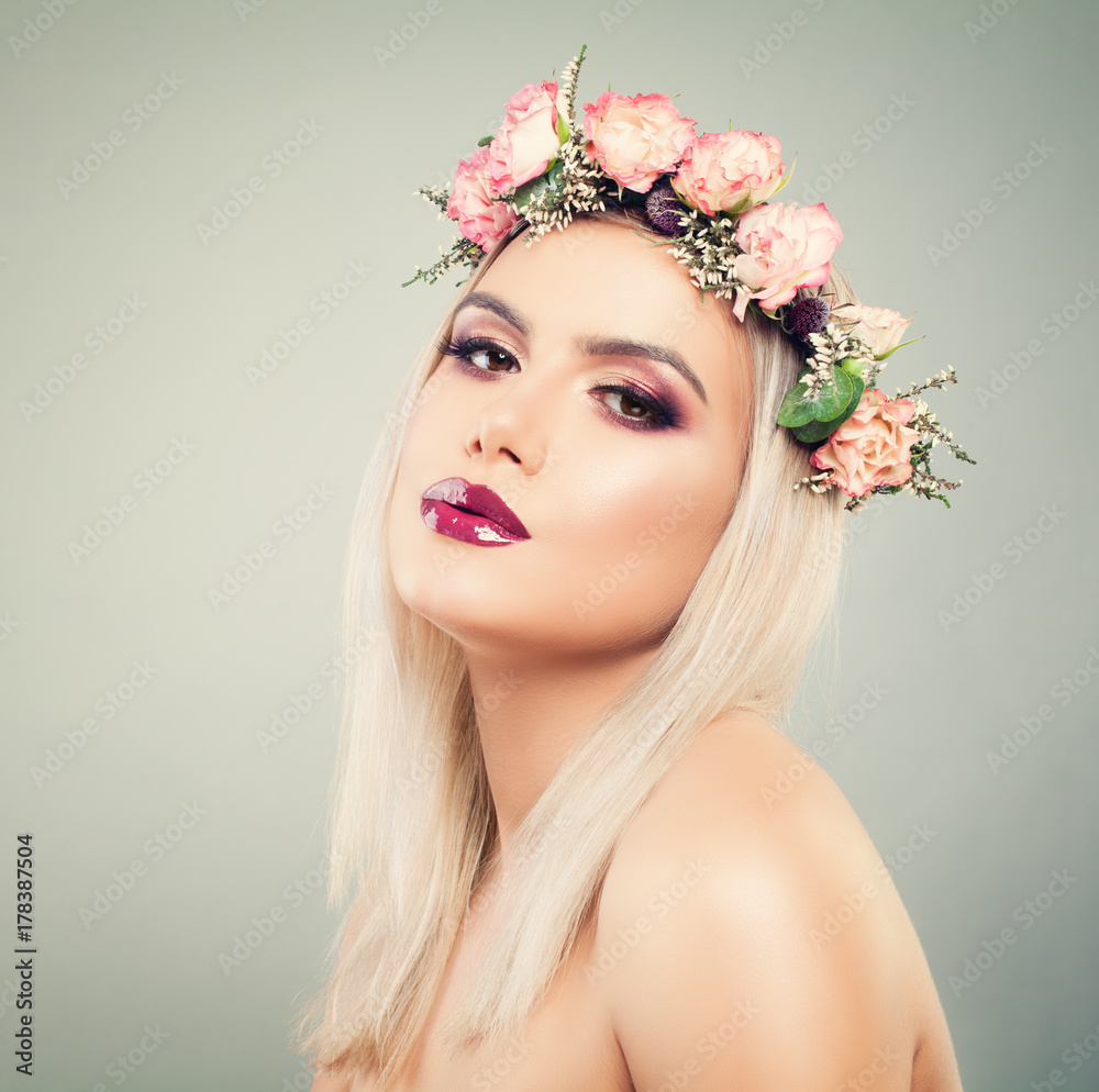 Beautiful Woman with Flowers in her Hair. Healthy Model with Makeup and Blonde Hairstyle