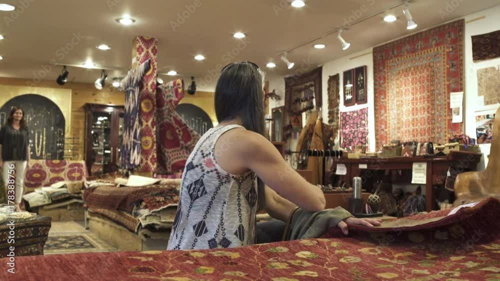 Medium shot of a couple looking at carpets in a shop Medium shot of a couple looking at carpets in a shop