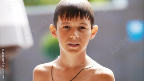 wet serious boy after a swimming pool looks at the camera, close-up