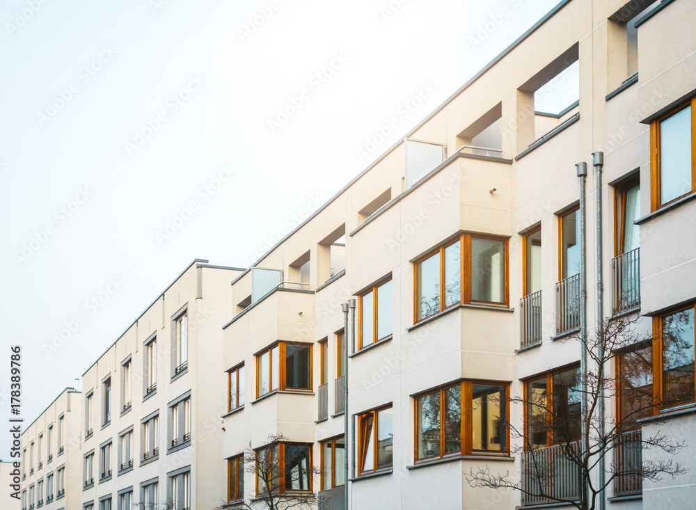 white apartment buildings in a row with wooden windows