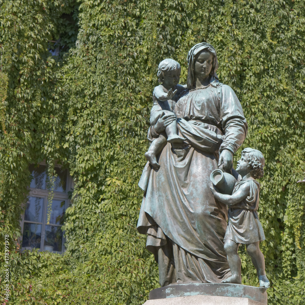 Figure of mother with children against green background