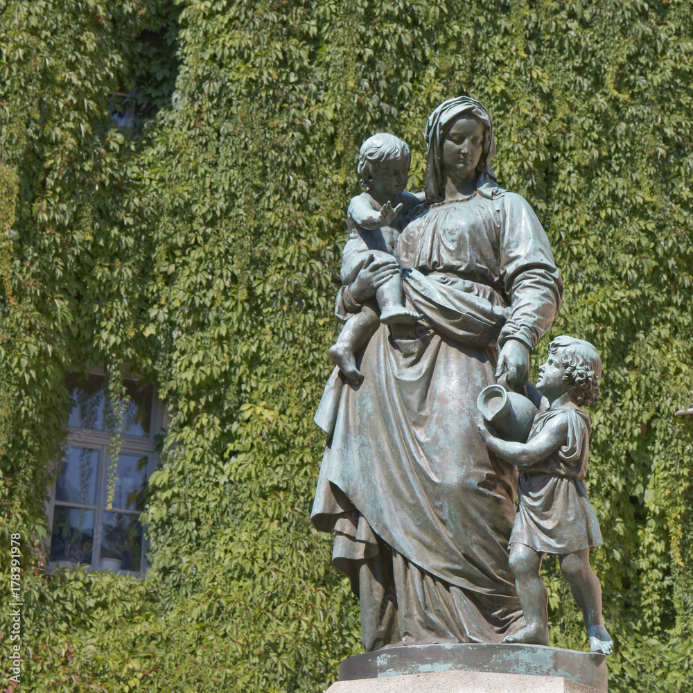 Figure of mother with children against green background
