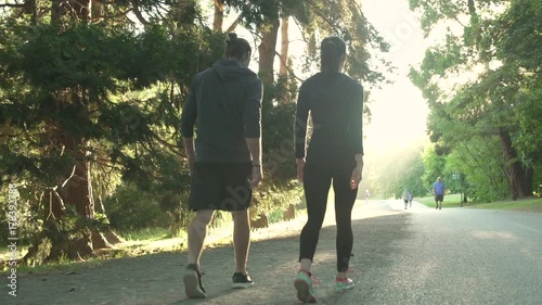 Two people walking in a park after running
