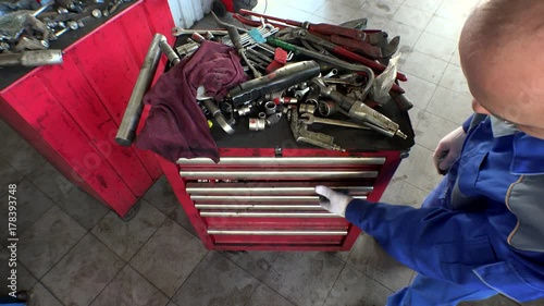 High angle view of male mechanic arranging tools in drawer