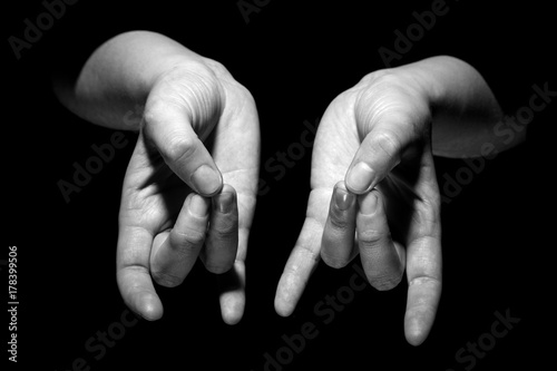 hands in mudra gesture on black background