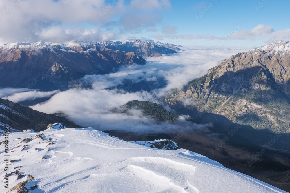 A view of the tops of the Caucasus Mountains and the valley in the clouds from the top of Mussa-Achitara Mountain in Dombai A view of the tops of the Caucasus Mountains and the valley in the clouds from the top of Mussa-Achitara Mountain in Dombai