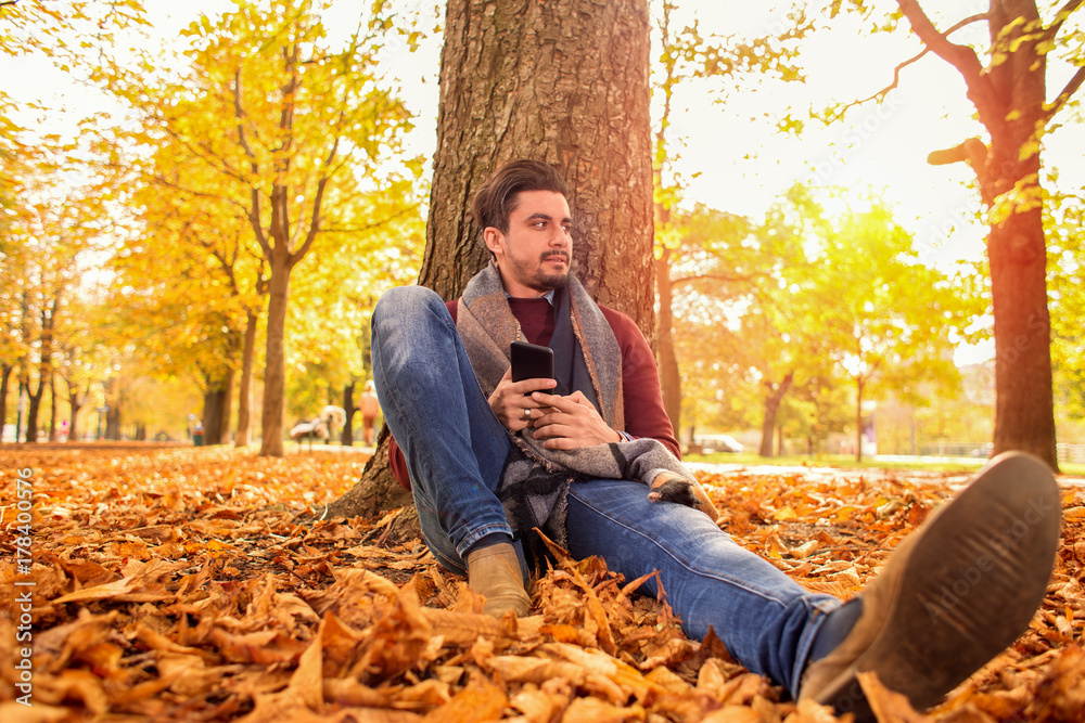 Handsome man taking a break at the park in autumn Handsome man taking a break at the park in autumn