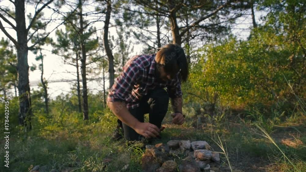 hiker man making campfire in forest hiker man making campfire in forest