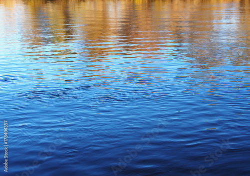 Water in the river and reflections of autumn trees