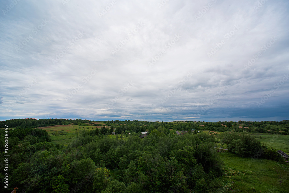 Landscape with clouds, forest and small houses Landscape with clouds, forest and small houses