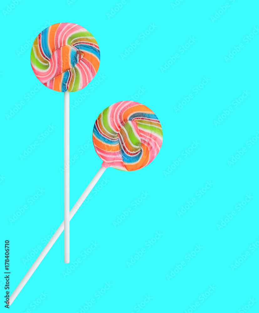 Colorful rainbow lollipop swirl on stick isolated on sweet pastel color background. Colorful rainbow lollipop swirl on stick isolated on sweet pastel color background.