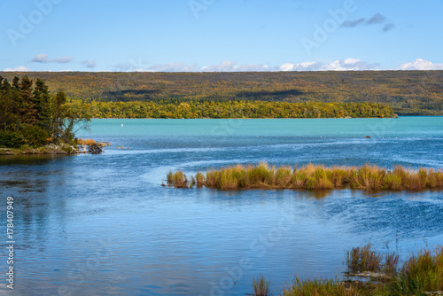 Fototapeta Naklejka Na Ścianę i Meble -  Peaceful landscape at Naknek Lake, Alaska, with glacial blue water, fall color, and a blue sky
