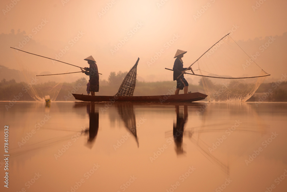 Obraz premium Two fishermen are fishing on the boat at Mekong river in the morning in Nong Khai, Thailand