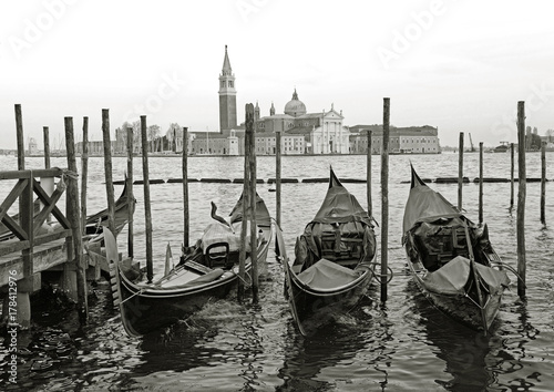 Black and white of Gondolas moored by Saint Mark square with San Giorgio di Maggiore church in the background - Venice, Venezia, Italy, Europe © aimy27feb