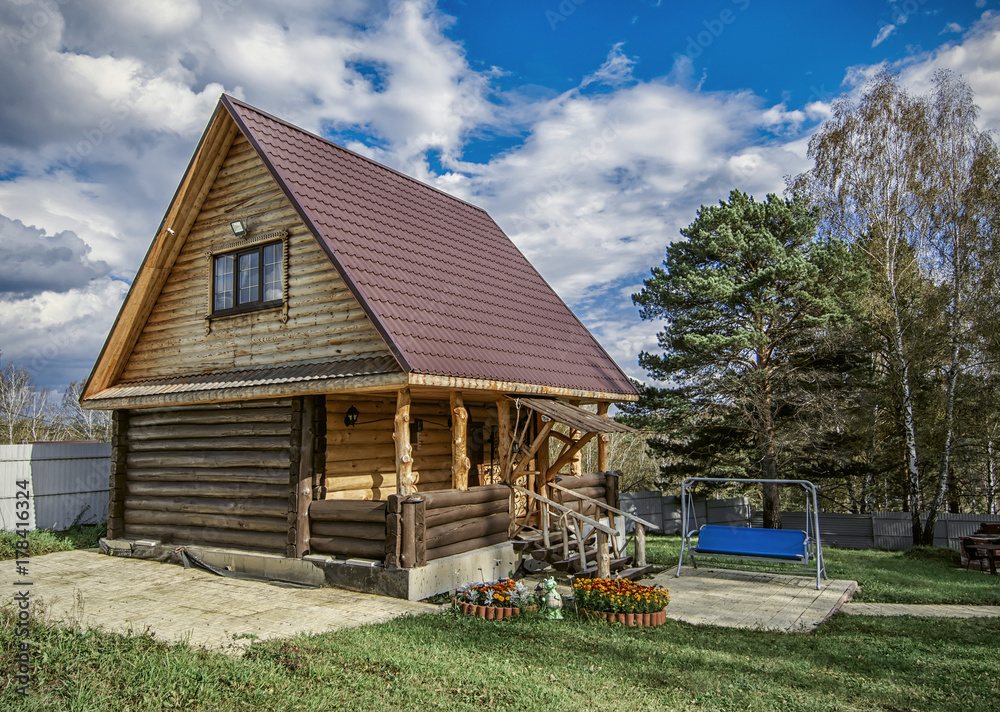 Small rural house in summer with blue seesaw sunny day