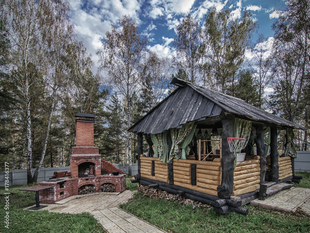 wooden gazebo and outdoor brick oven in backyard