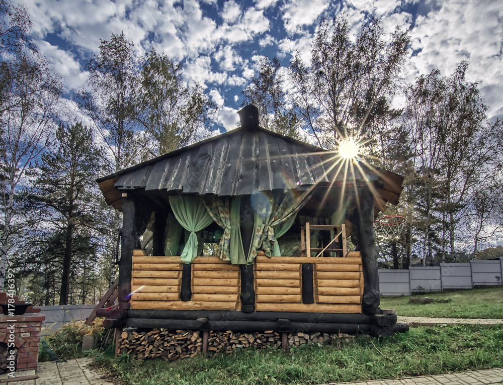 Landscape with sunny day and wooden rustic gazebo