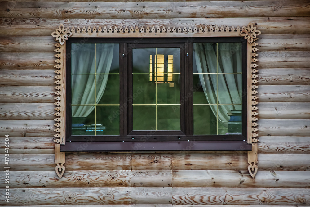 Window with decorative bars on the wooden wall
