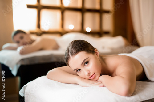 Calm girl lying in spa salon and relaxing before or after body massage