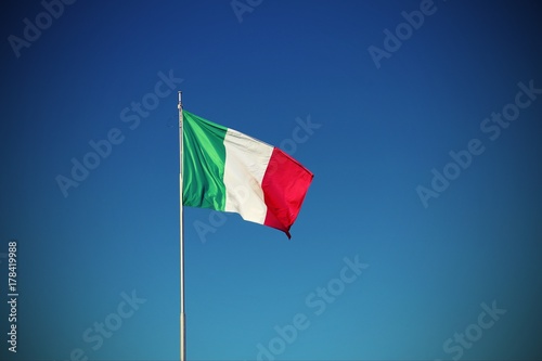 Italian flag waving with blue sky with vignette effect