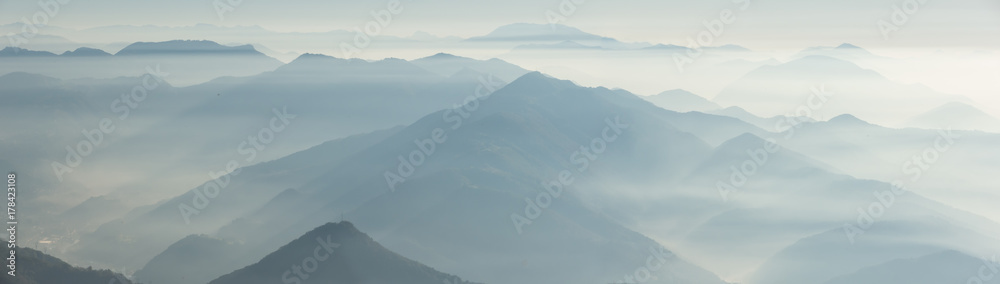 Morning landscape on hills and mountains with humidity in the air and pollution. Panorama from Linzone Mountain, Bergamo, Italy Morning landscape on hills and mountains with humidity in the air and pollution. Panorama from Linzone Mountain, Bergamo, Italy