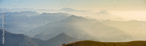 Morning landscape on hills and mountains with humidity in the air and pollution. Panorama from Linzone Mountain, Bergamo, Italy photo