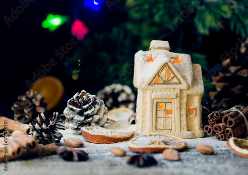 Christmas card with little toy house and decorations on a wooden rustic table, selective focus