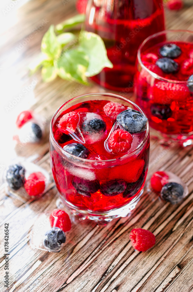 Summer berry lemonade with frozen berries on a wooden rustic table, selective focus Summer berry lemonade with frozen berries on a wooden rustic table, selective focus