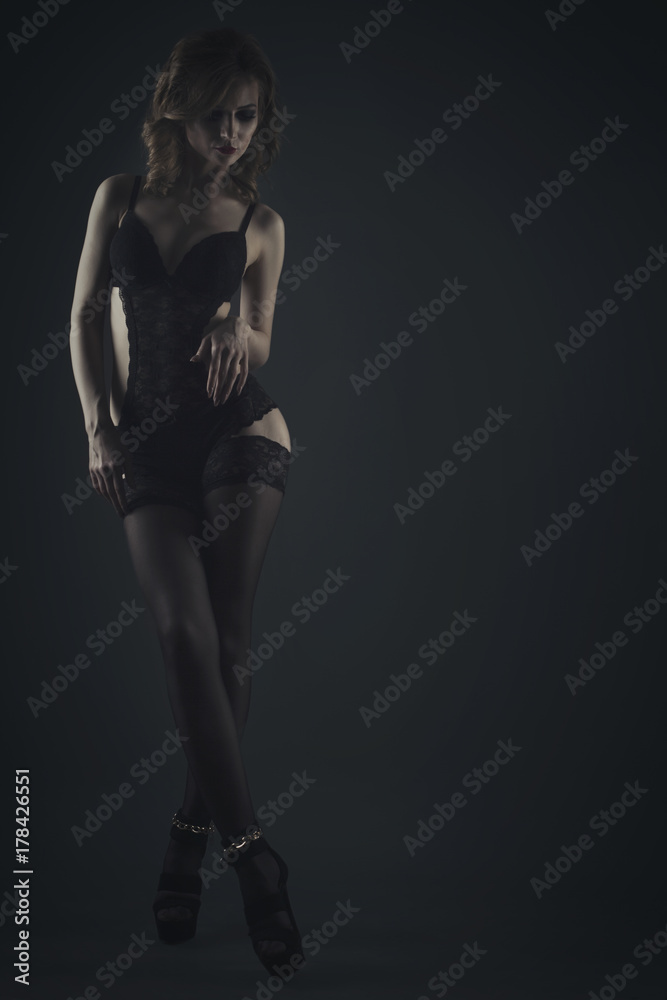 Woman in black lingerie on a dark background studio shot Woman in black lingerie on a dark background studio shot