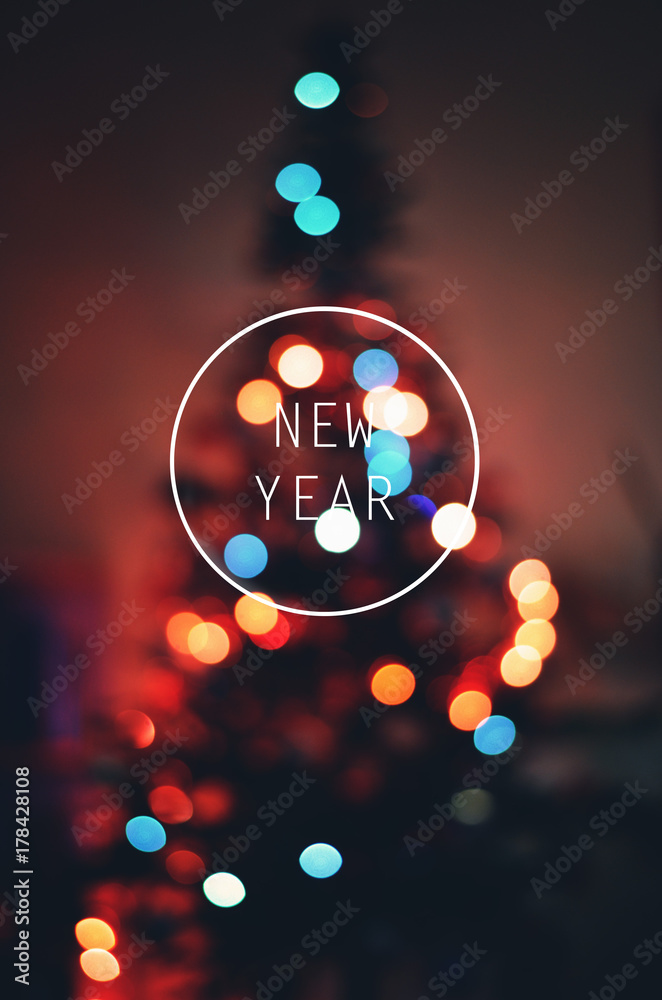 new year text with xmas tree bokeh blur