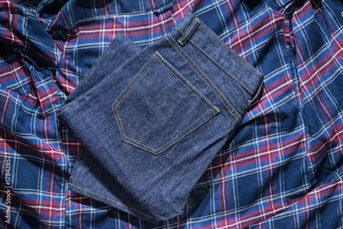 Blue Jeans Denim, 100% Cotton Unsanforized Denim Red Selvage Jeans on Plaid Shirt background, selective focus (detailed close-up shot) photo