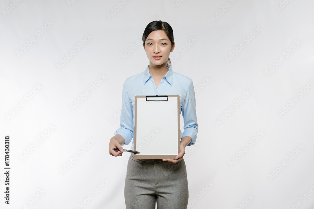 Young Asian business woman point to blank clipboard isolated on white background Young Asian business woman point to blank clipboard isolated on white background