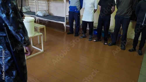 Convicts stand infront the prison officer inside the cell of the correctional colony, Russia