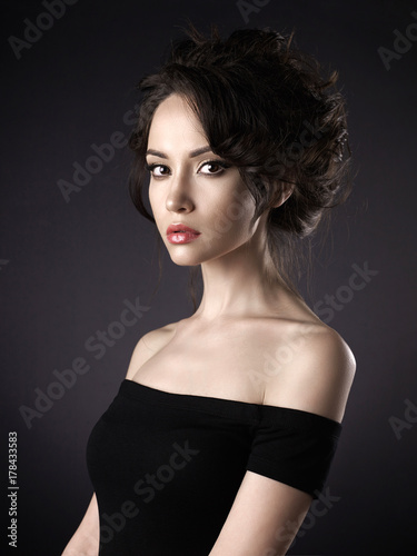 Beautiful woman with elegant hairstyle on black background