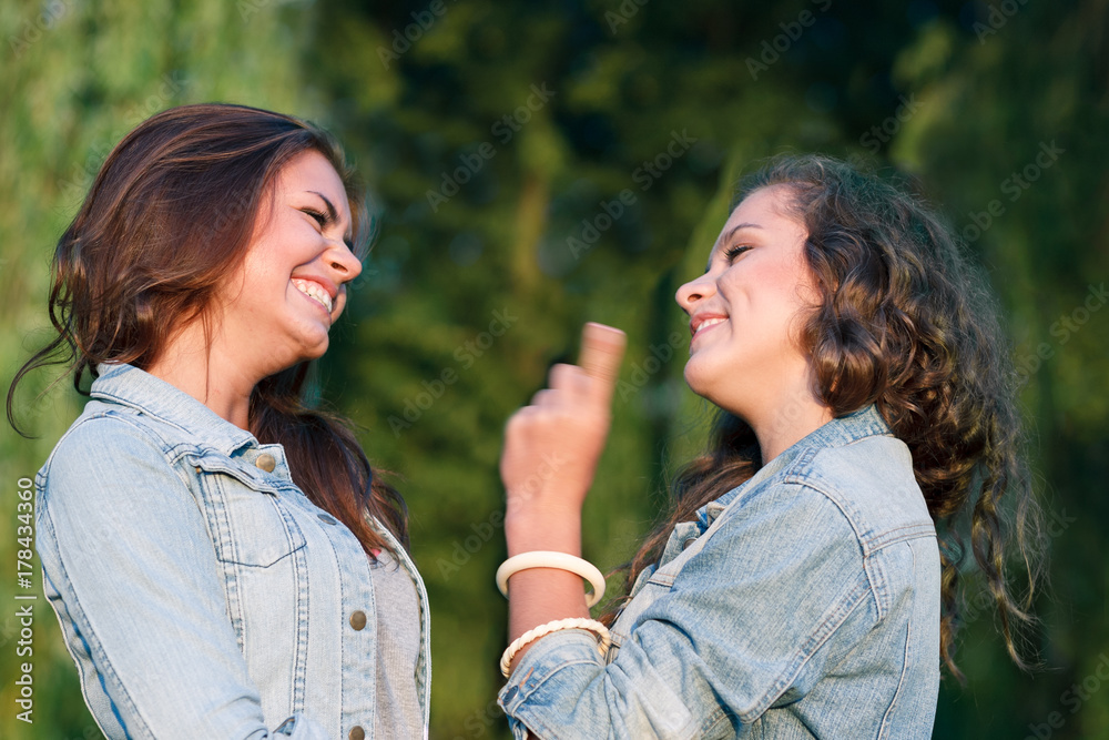 two young woman talking smiling park two young woman talking smiling park