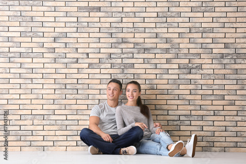 Happy young couple sitting ...