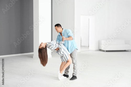 Happy young couple dancing in their new apartment
