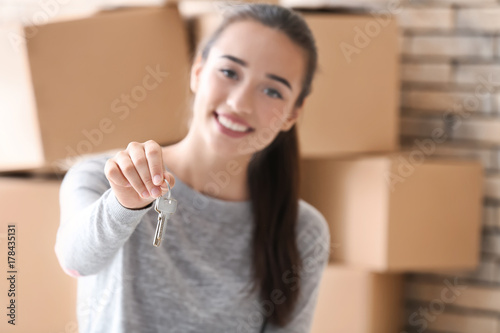 Happy young woman holding k...