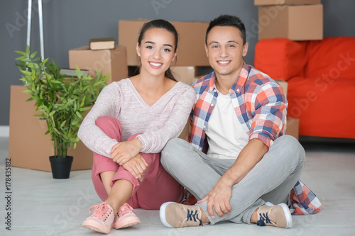 Happy young couple sitting ...