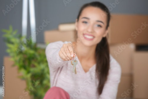 Happy young woman holding k...